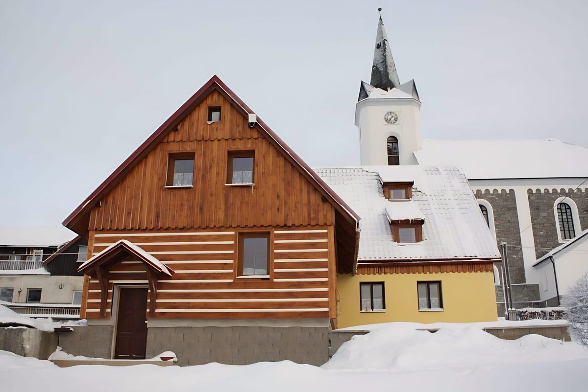 Chata Dáša pod sněhem vedle příchovického kostela